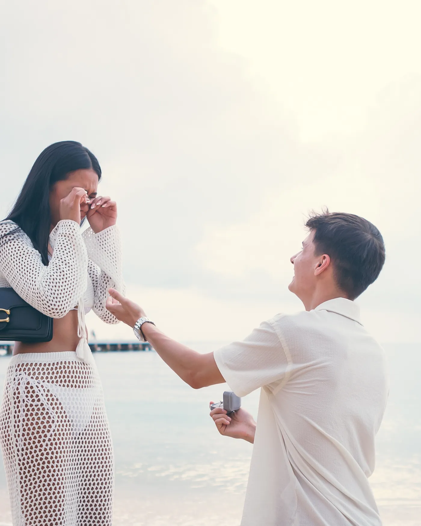 Gabriel on one knee proposing to Thipwaree on the beach